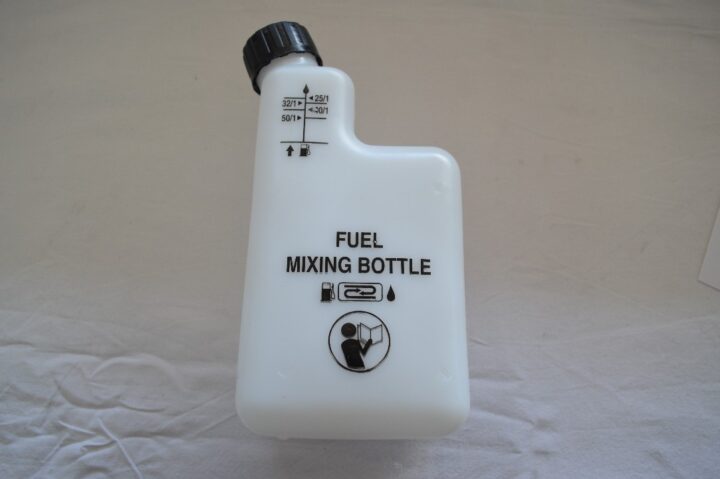 White fuel mixing bottle with a black cap and measurement markings on the neck, labeled 'FUEL MIXING BOTTLE'.