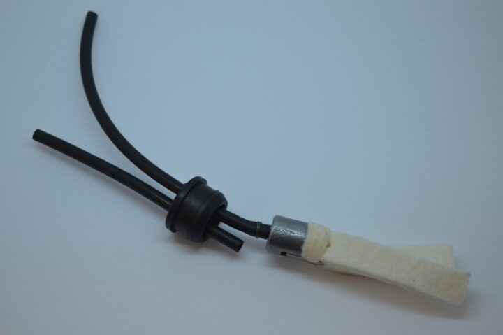 Close-up of a black rubber hose assembly with a metal connector wrapped in white fabric.