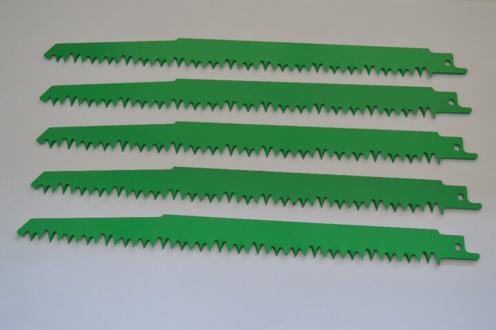 Five green serrated blades laid out on a white background