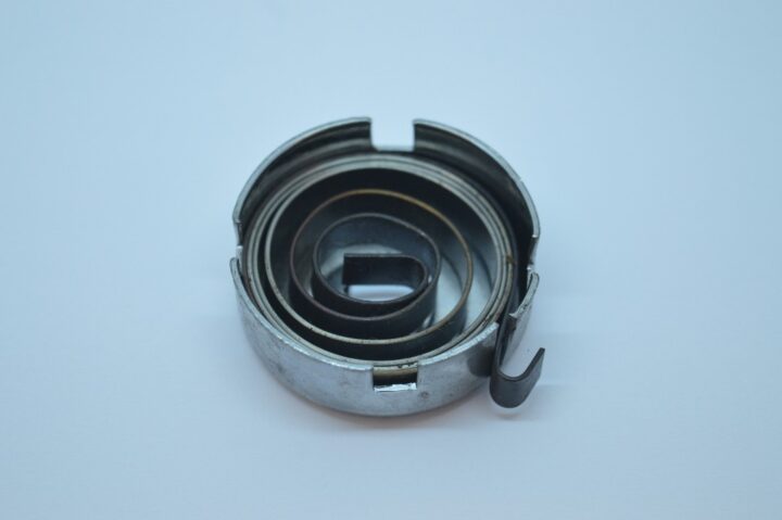 Inner spring mechanism of a retractable tape measure inside a circular metal housing