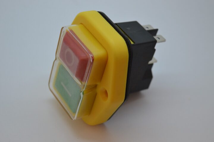 Yellow dual-color push-button switch with red and green faces in a plastic housing